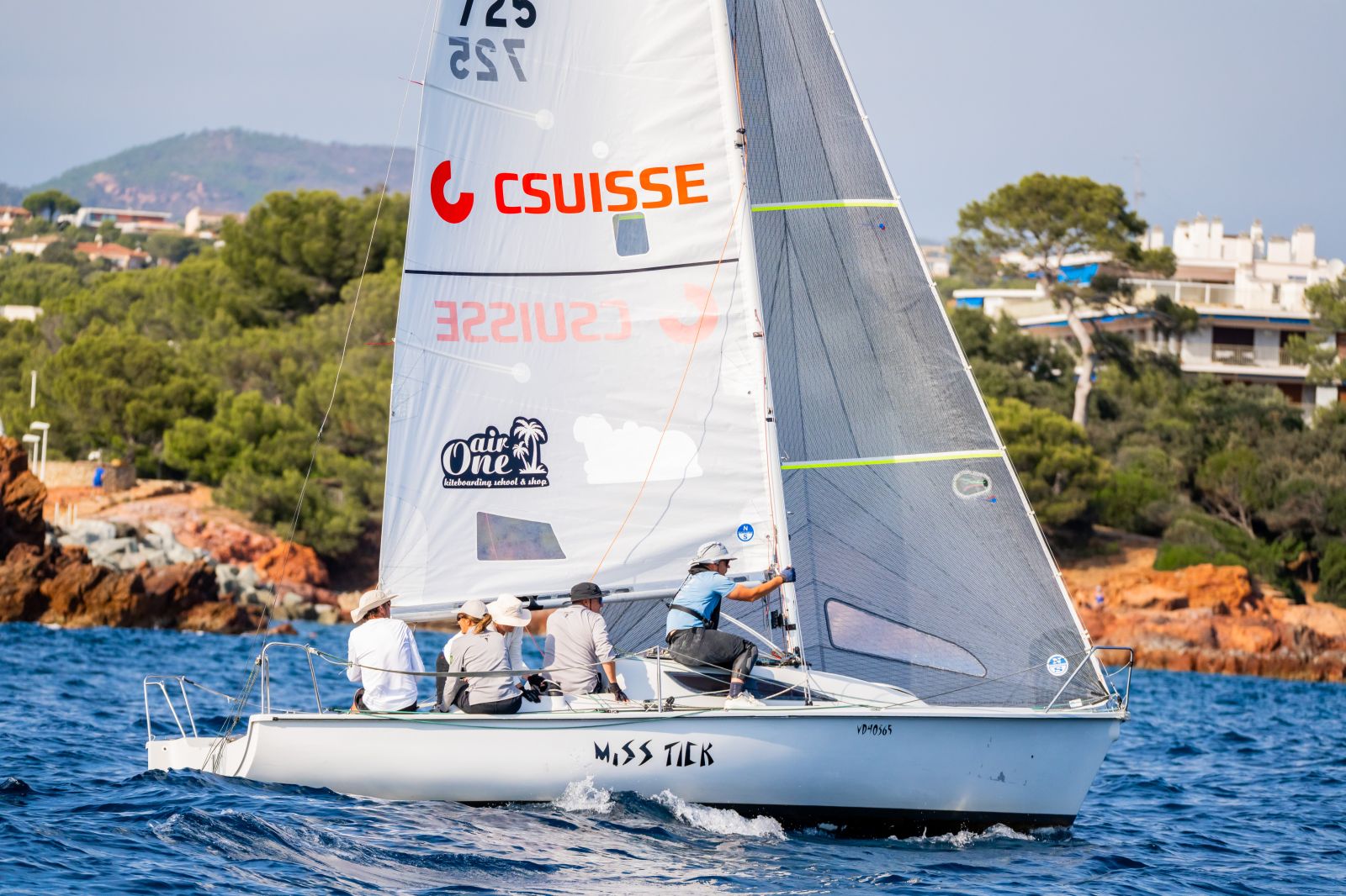 Un Surprise au portant, le nom du partenaire lisible sur la grand-voile